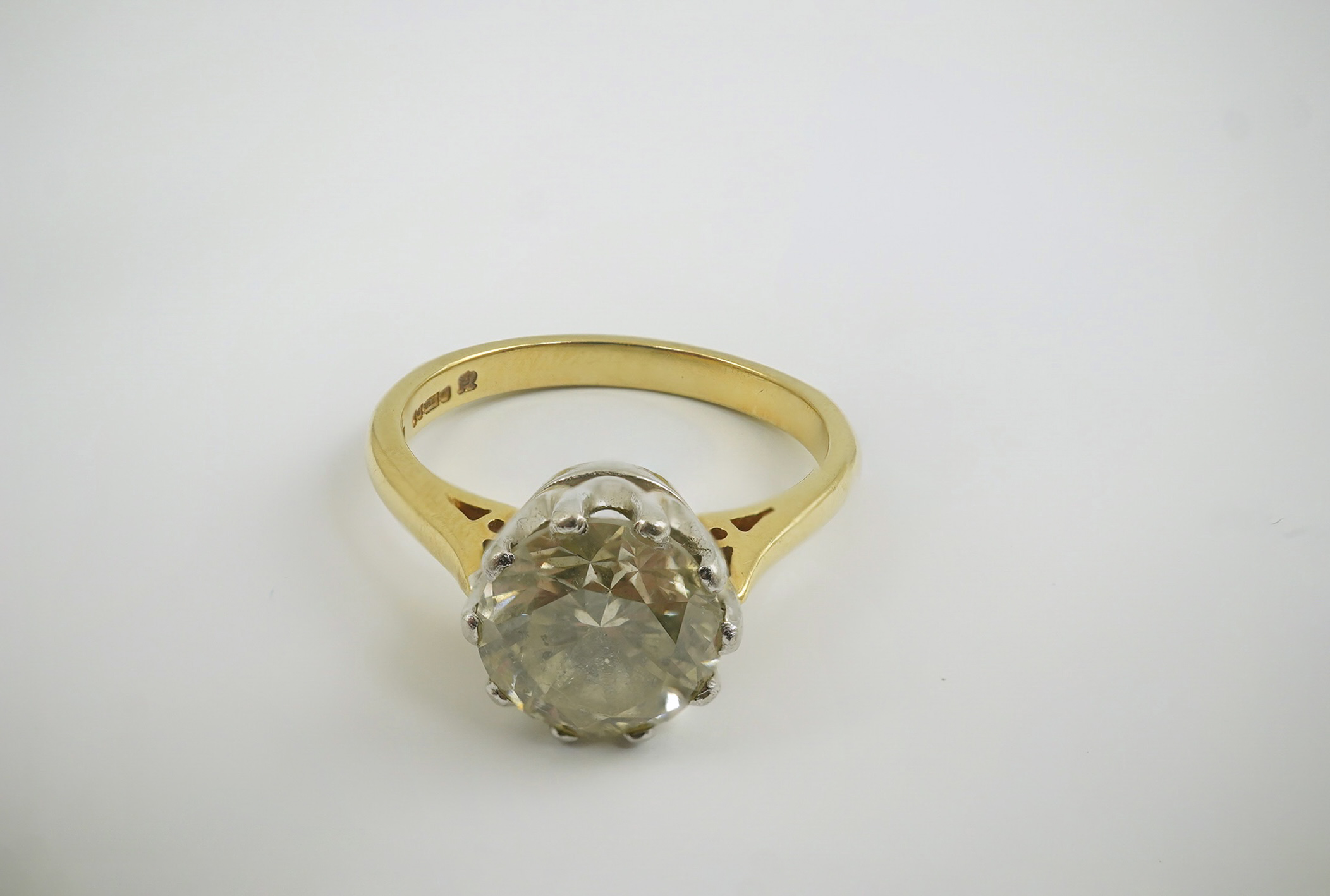 A modern 18ct gold and solitaire round cut diamond set ring